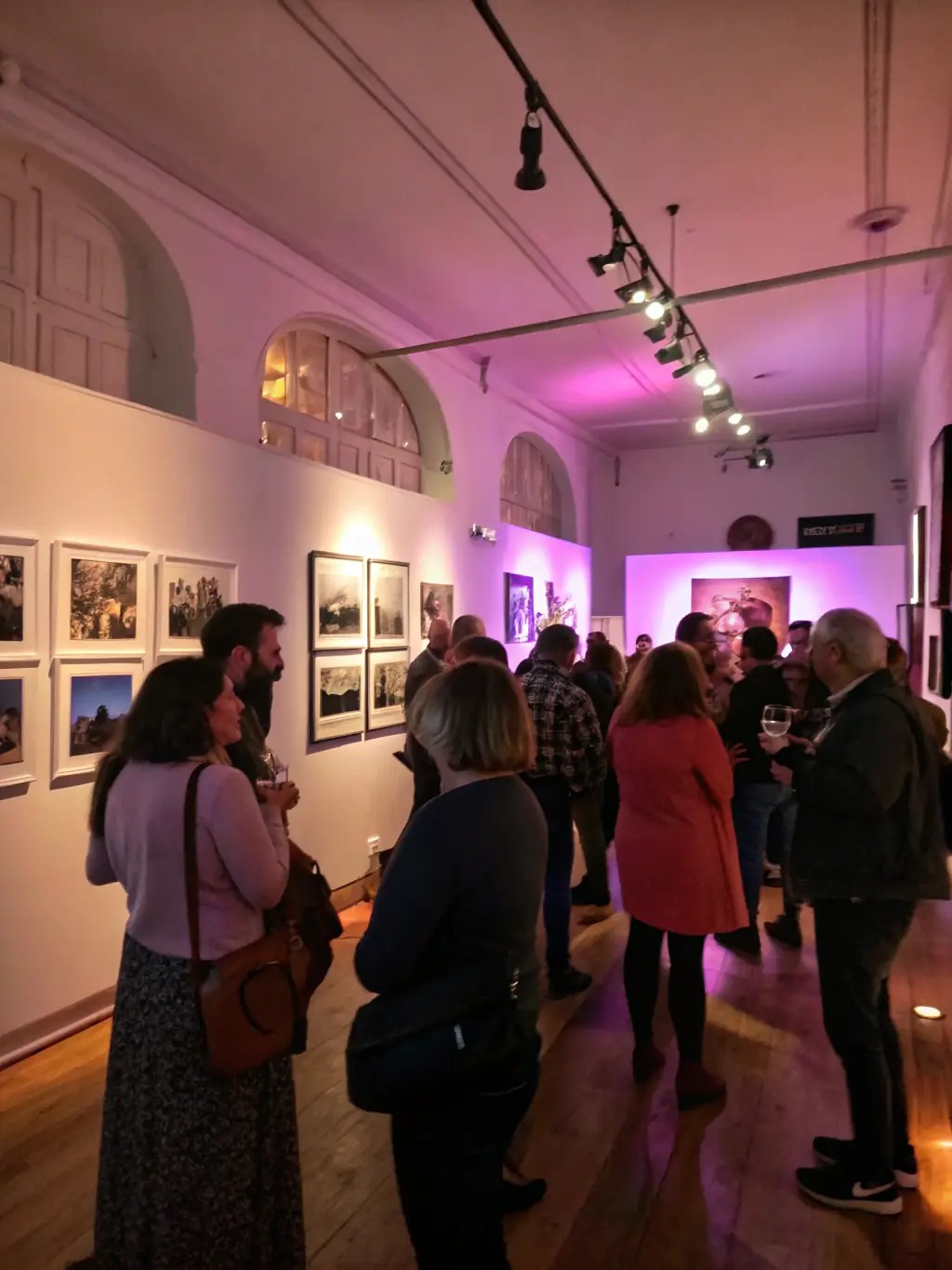 A photograph capturing the opening night of an art exhibition at LA CONSERVERIE DE BENEVENT, showcasing local artists and attendees engaging with the artwork.